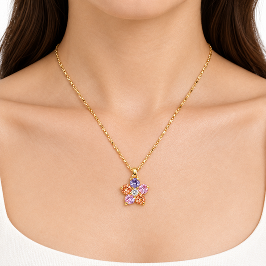 Modelka prezentuje pozlacany naszyjnik z wielokolorowa kwiatowa zawieszka