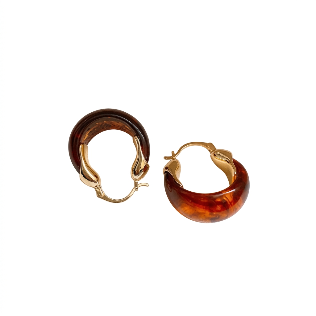 Para małych brązowo-bursztynowych kolczyków z żywicy ze złotymi zapięciami na białym tle